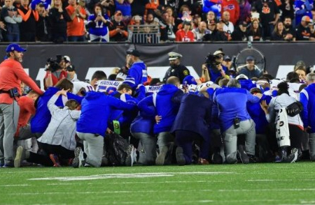The Buffalo Bills team gathers in prayer following the near-fatal collapse of Damar Hamlin on the field. Image of The Buffalo Bills team gathers in prayer following the near-fatal collapse of Damar Hamlin on the field.