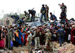 Uzbek refugees crowd around an armoured vehicle with Kyrgyz soldiers in the southern city of Osh while waiting to cross the border into Uzbekistan. Image of Uzbek refugees crowd around an armoured vehicle with Kyrgyz soldiers in the southern city of Osh while waiting to cross the border into Uzbekistan.