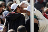 Pope Francis kisses Livio Bastianelli and Davide Maria goodbye after their lucky ride. Image of Pope Francis kisses Livio Bastianelli and Davide Maria goodbye after their lucky ride.