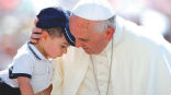 Pope Francis embraces a child in St. Peter's Square. Image of Pope Francis embraces a child in St. Peter's Square.