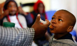 A boy is given a dose of medication in a South African clinic. Despite the progress of the past year, much more remains to be done. Doctors are hopeful however, the nation has turned a corner. Image of A boy is given a dose of medication in a South African clinic. Despite the progress of the past year, much more remains to be done. Doctors are hopeful however, the nation has turned a corner.