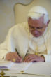 Pope Benedict signs a bound copy of his encyclical. Image of Pope Benedict signs a bound copy of his encyclical.