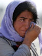 A Yazidi woman cries in a refugee camp where most of her surviving people now live. Image of A Yazidi woman cries in a refugee camp where most of her surviving people now live.