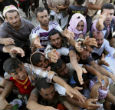 Iraqi refugees hungrily receive a shipment of food aid, which has become even more scarce now the UN has halted shipments. Image of Iraqi refugees hungrily receive a shipment of food aid, which has become even more scarce now the UN has halted shipments.