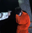 ISIS ties two men to a tree to be shot. Image of ISIS ties two men to a tree to be shot.
