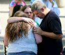 Survivors embrace and pray in the aftermath of the shooting which left 9 people and the shooter dead. Image of Survivors embrace and pray in the aftermath of the shooting which left 9 people and the shooter dead.