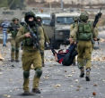 Israeli soldiers carry off wounded Palestinian, who they accuse of going on a stabbing rampage. Image of Israeli soldiers carry off wounded Palestinian, who they accuse of going on a stabbing rampage.