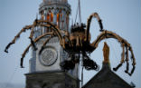 The giant spider woke up on cue, and walked into the streets below, amazing the crowd. But not everybody appreciated the display. Image of The giant spider woke up on cue, and walked into the streets below, amazing the crowd. But not everybody appreciated the display.