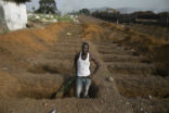 A man digs a grave for Ebola victims during the outbreak in West Africa. The 2014-1026 outbreak was the most serious in history and its global spread was only prevented by swift action by international health officials. Image of A man digs a grave for Ebola victims during the outbreak in West Africa. The 2014-1026 outbreak was the most serious in history and its global spread was only prevented by swift action by international health officials.
