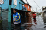 People walk though flooded streets in the aftermath of Maria. Several places remain flooded. Image of People walk though flooded streets in the aftermath of Maria. Several places remain flooded.