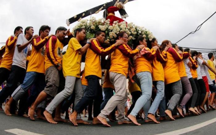 Catholics carry a replica of the Black Nazarene during a procession ahead of feast day celebrations in Manila. Catholics carry a replica of the Black Nazarene during a procession ahead of feast day celebrations in Manila.