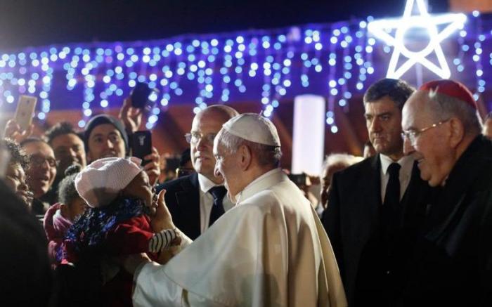 Pope Francis greets a child in the crowd outside the church after celebrating Mass in the parish of St Mary.