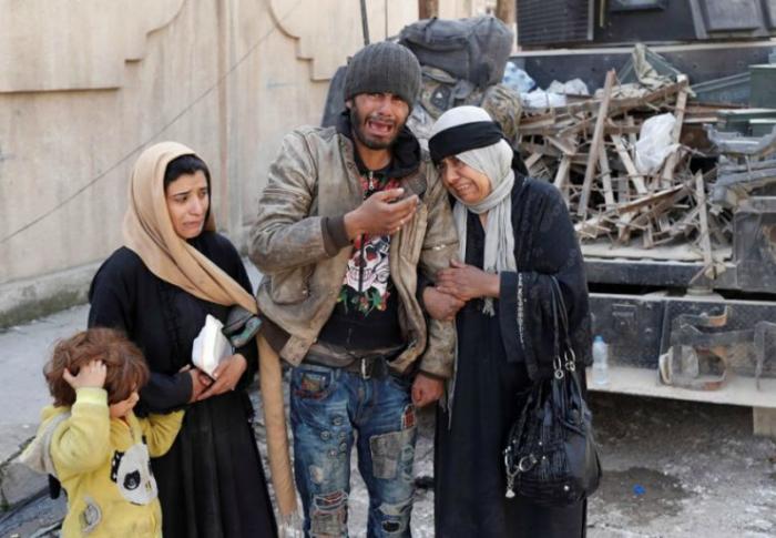 A family trying to escape fighting between Iraqi forces and ISIS fighters cry on a street in Mosul, Iraq. A family trying to escape fighting between Iraqi forces and ISIS fighters cry on a street in Mosul, Iraq.