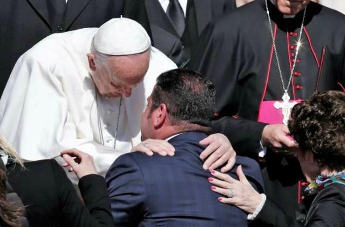 Pope Francis embraces a man at the Wednesday General Audience.
