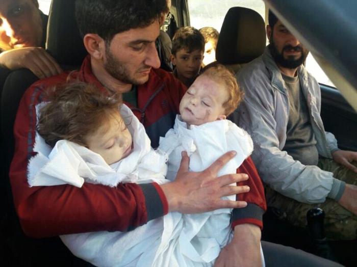 A father holds the bodies of his two children killed in the gas attack.