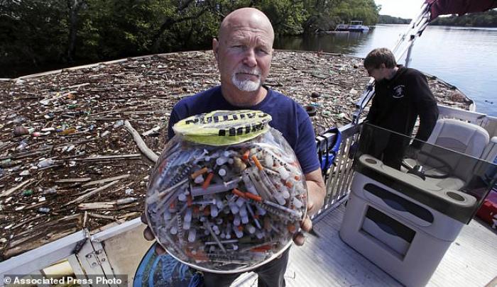 Rocky Morrison, from the Clean River Project in Methuen, Massachusetts holds up a bowl of syringes he has found. The bowl provides a shocking example of how plentiful discarded needles are. Rocky Morrison, from the Clean River Project in Methuen, Massachusetts holds up a bowl of syringes he has found. The bowl provides a shocking example of how plentiful discarded needles are.