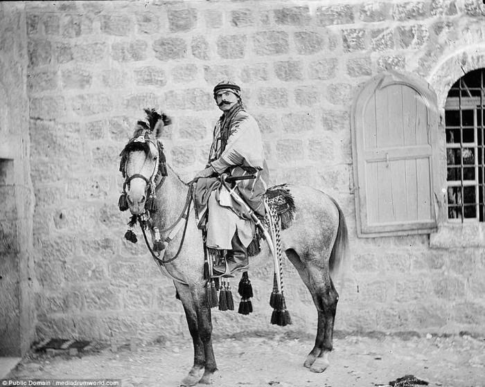 A Bedouin man sits on an elaborately saddled horse in Jerusalem. 