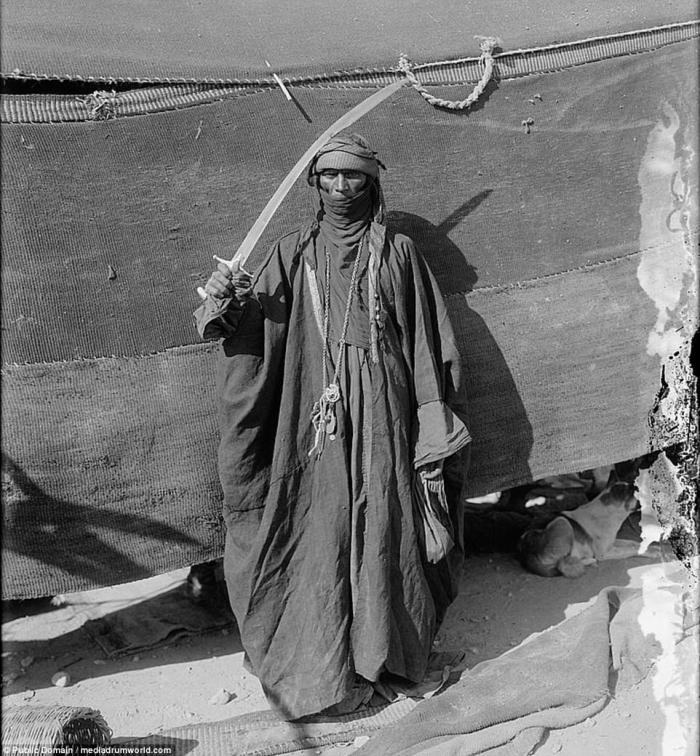 A Bedouin man poses with his sword. Despite the weapon, Bedouins generally lead a peaceful existence, traveling raising animals, and trading as they go. 