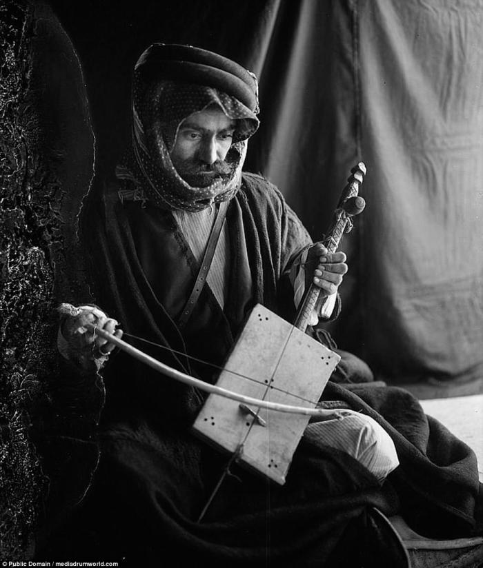 A Bedouin man poses with a traditional musical instrument. 