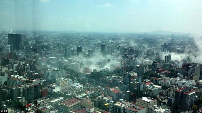 Dust rises from collapsed buildings and other damage. Dust rises from collapsed buildings and other damage.