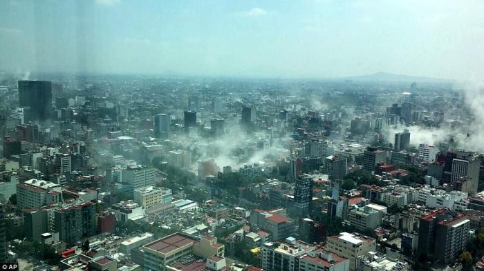 Dust rises from collapsed buildings and other damage. 