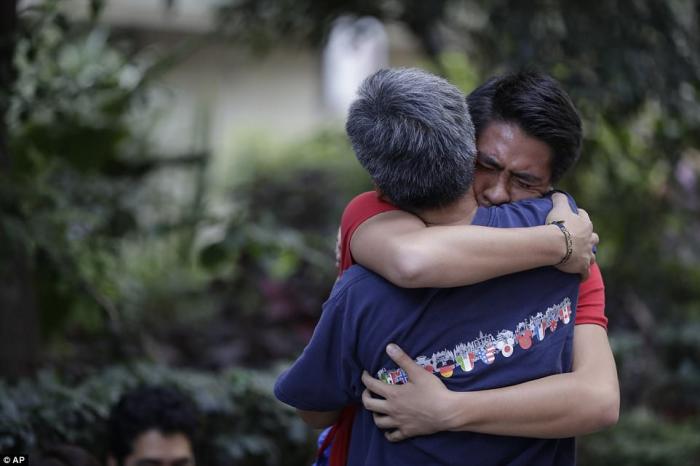 A pair of relatives embrace after finding one another unhurt. This was the most common scene in the city, but the focus remains on locating trapped survivors. 