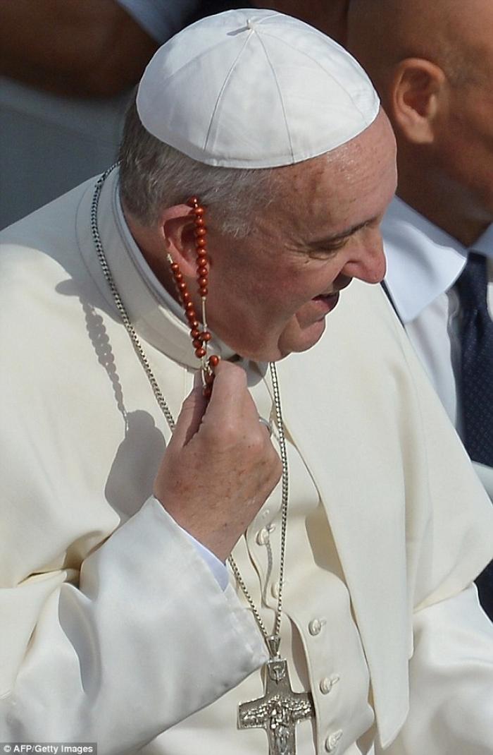 Surprised by the gift, Pope Francis gently removed it from his ear. Surprised by the gift, Pope Francis gently removed it from his ear.