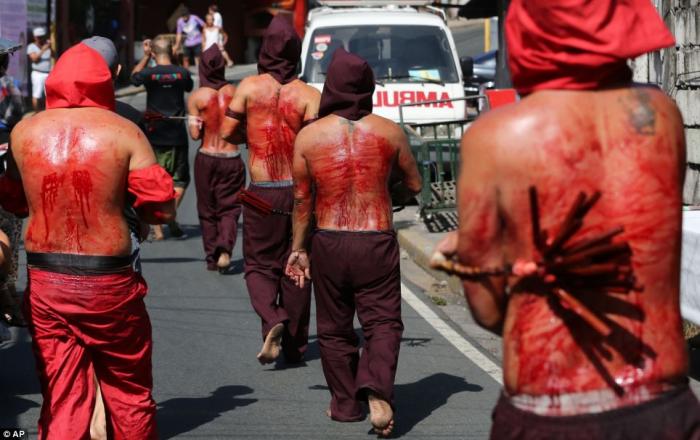 Hooded penitents in the Philippines flagellate themselves as part of the Maundy Thursday rituals to Hooded penitents in the Philippines flagellate themselves as part of the Maundy Thursday rituals to