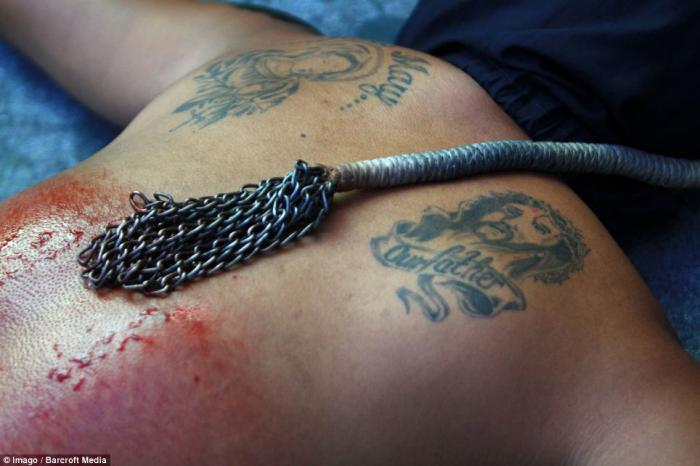 A penitent lies on the ground after flagellating himself during a Holy Week ritual to atone for his A penitent lies on the ground after flagellating himself during a Holy Week ritual to atone for his