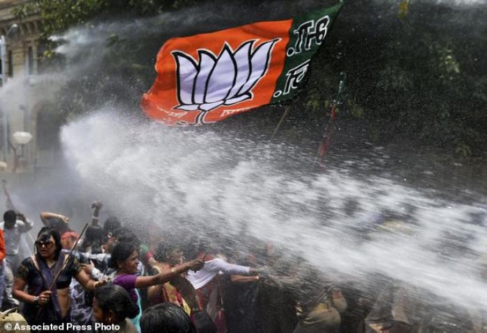 Women activists of Bharatiya Janata Party, flag seen top, face police water cannons as they demonstr Women activists of Bharatiya Janata Party, flag seen top, face police water cannons as they demonstr