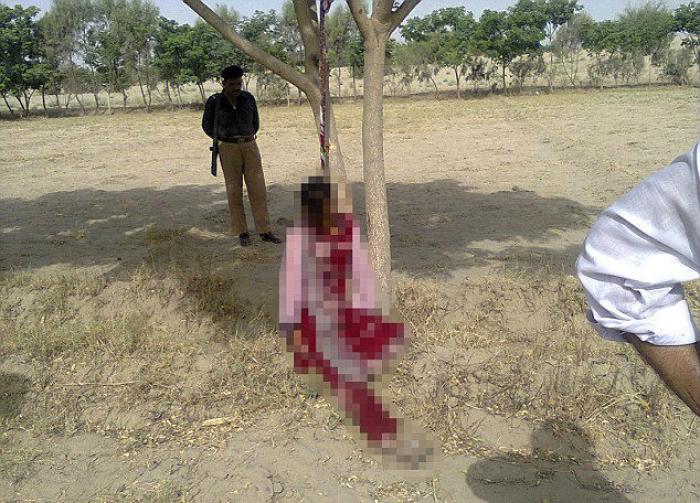 A policeman stands near the body of Muzammil Bibi, 20, after policemen lowered her to the ground. Sh A policeman stands near the body of Muzammil Bibi, 20, after policemen lowered her to the ground. Sh