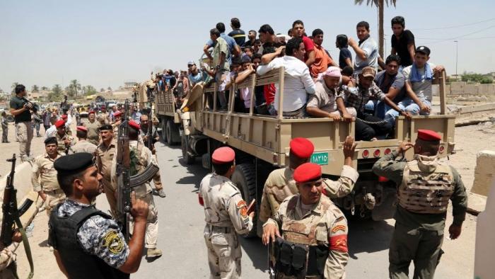 Iraqi men board military trucks to join the Iraqi army at the main recruiting center in Baghdad, Ira Iraqi men board military trucks to join the Iraqi army at the main recruiting center in Baghdad, Ira
