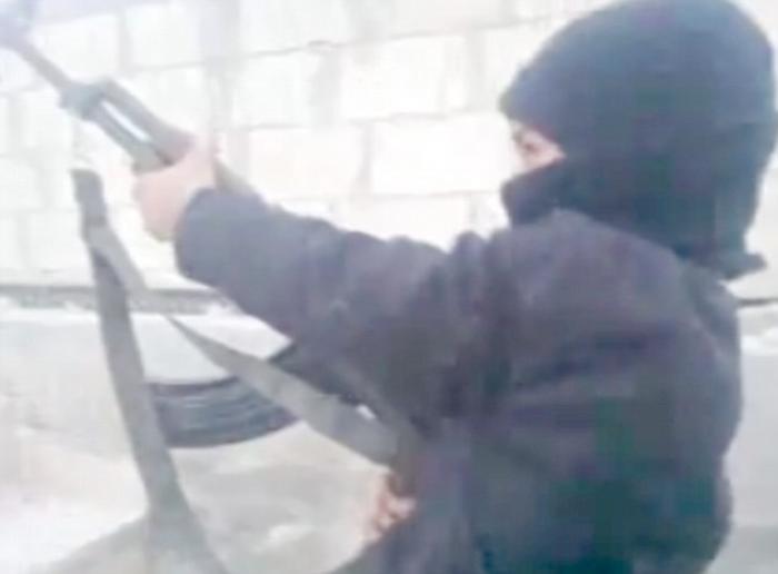 The footage shows a masked child firing an AK47 assault rifle while shouting Islamic slogans. It was The footage shows a masked child firing an AK47 assault rifle while shouting Islamic slogans. It was