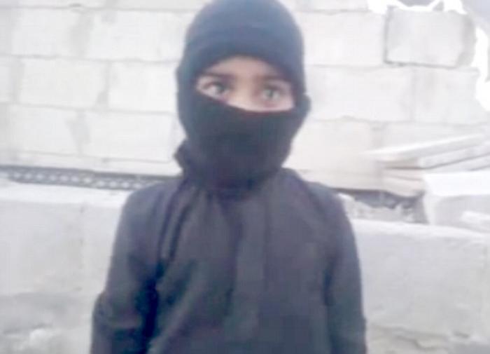 The young boy, who appears no older than six-years-old, is instructed to fire the weapon by an adult The young boy, who appears no older than six-years-old, is instructed to fire the weapon by an adult