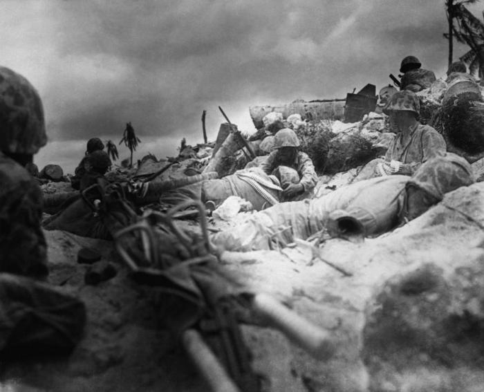 Marines on the beach under fire from Japanese defensive positions. Marines on the beach under fire from Japanese defensive positions.