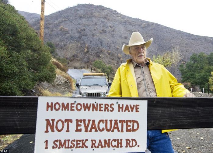 Resident Tom Smisek stands at a warning sign in Silverado Canyon, California on Tuesday. Resident Tom Smisek stands at a warning sign in Silverado Canyon, California on Tuesday.