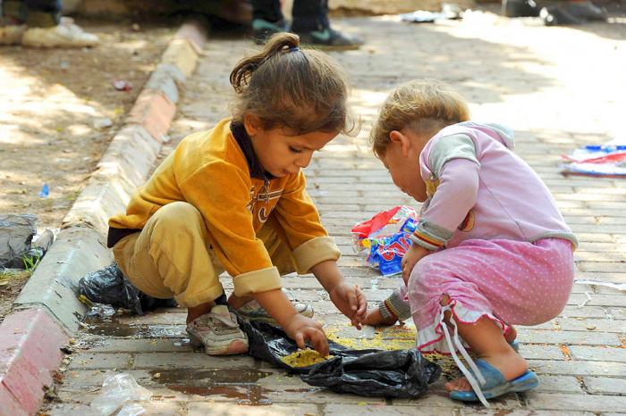 Children feast on crumbs harvested from a gutter, revealing just how desperate many of the people ar Children feast on crumbs harvested from a gutter, revealing just how desperate many of the people ar