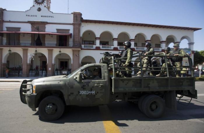 Soldiers patrol City Hall in Apatzingan, Mexico, last year during tense standoff with vigilantes. Soldiers patrol City Hall in Apatzingan, Mexico, last year during tense standoff with vigilantes.